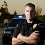 Cop posing in front of car