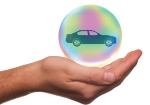 Hand holding a car in a bubble