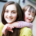 Girl giving a child a piggy back ride