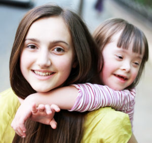 Girl giving a child a piggy back ride