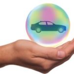 Hand holding car in a bubble