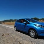 Blue car on side of highway