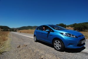 Blue car on side of highway