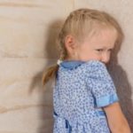 Child standing in the corner