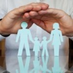 Man placing hands over paper family
