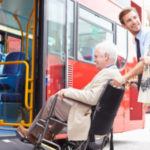 Man helping senior couple board bus