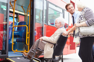 Man helping senior couple board bus