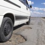 White truck going through potholes