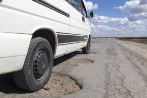 White truck going through potholes