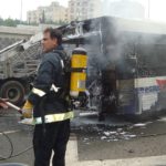 Firemen extinguishing fire on bus