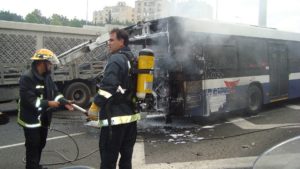 Firemen extinguishing fire on bus