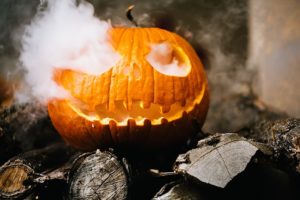 one jack-o-lantern on wood with smoke rising