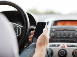 man driving while using phone