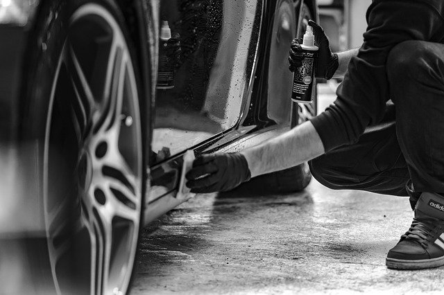 Auto worker is cleaning a car