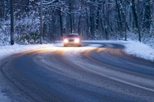 Car with high beams driving on snowy road